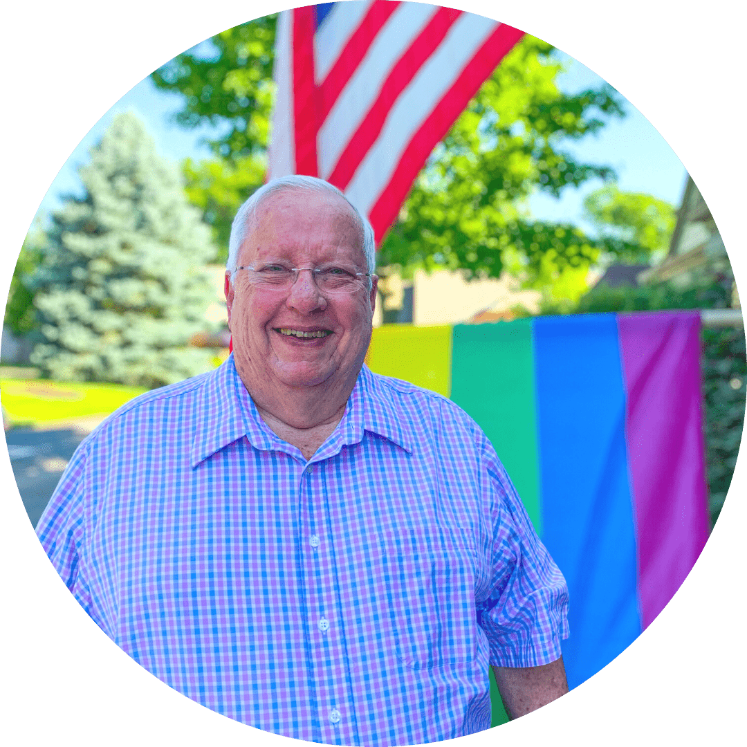 a man standing in front of a pride flag and american flag